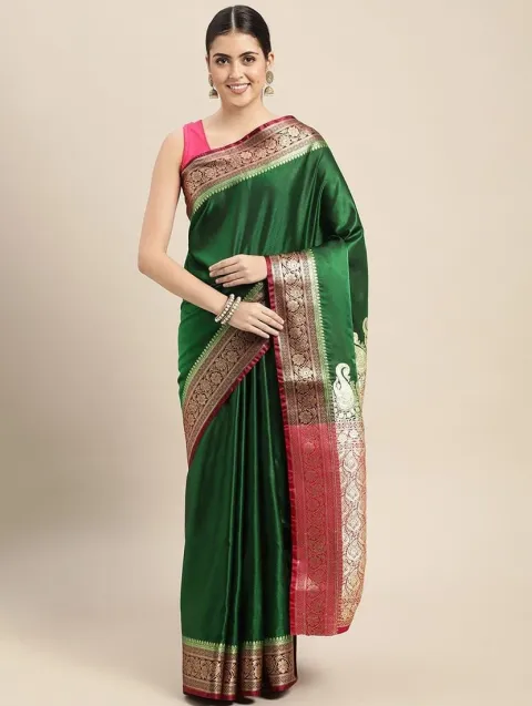 A model wearing an emerald green Banarasi saree with a pink and gold zari border